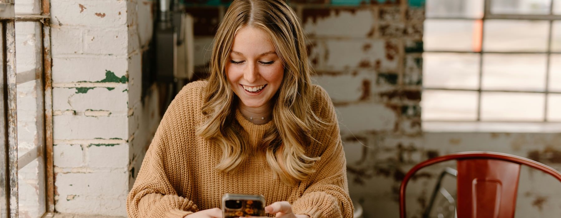 a woman smiling and holding a phone