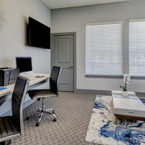 a living room with a desk and computer